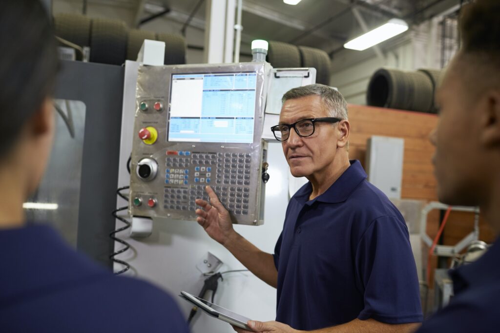 Engineer Training Apprentices On CNC Machine